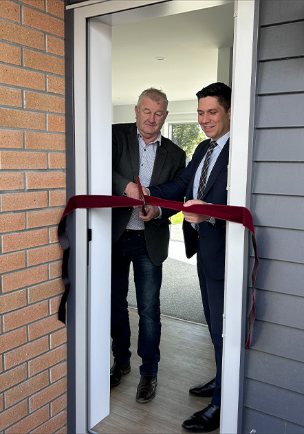 Two men cut ribbon