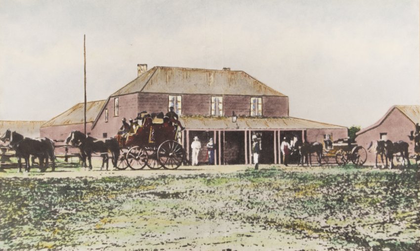 Hand-coloured photographic print of John and Thomas Turton's New Inn, built in 1866. Front view of two-storeyed wooden building, Victorian pedestrians and horse-drawn carriage outside on the unsealed road.