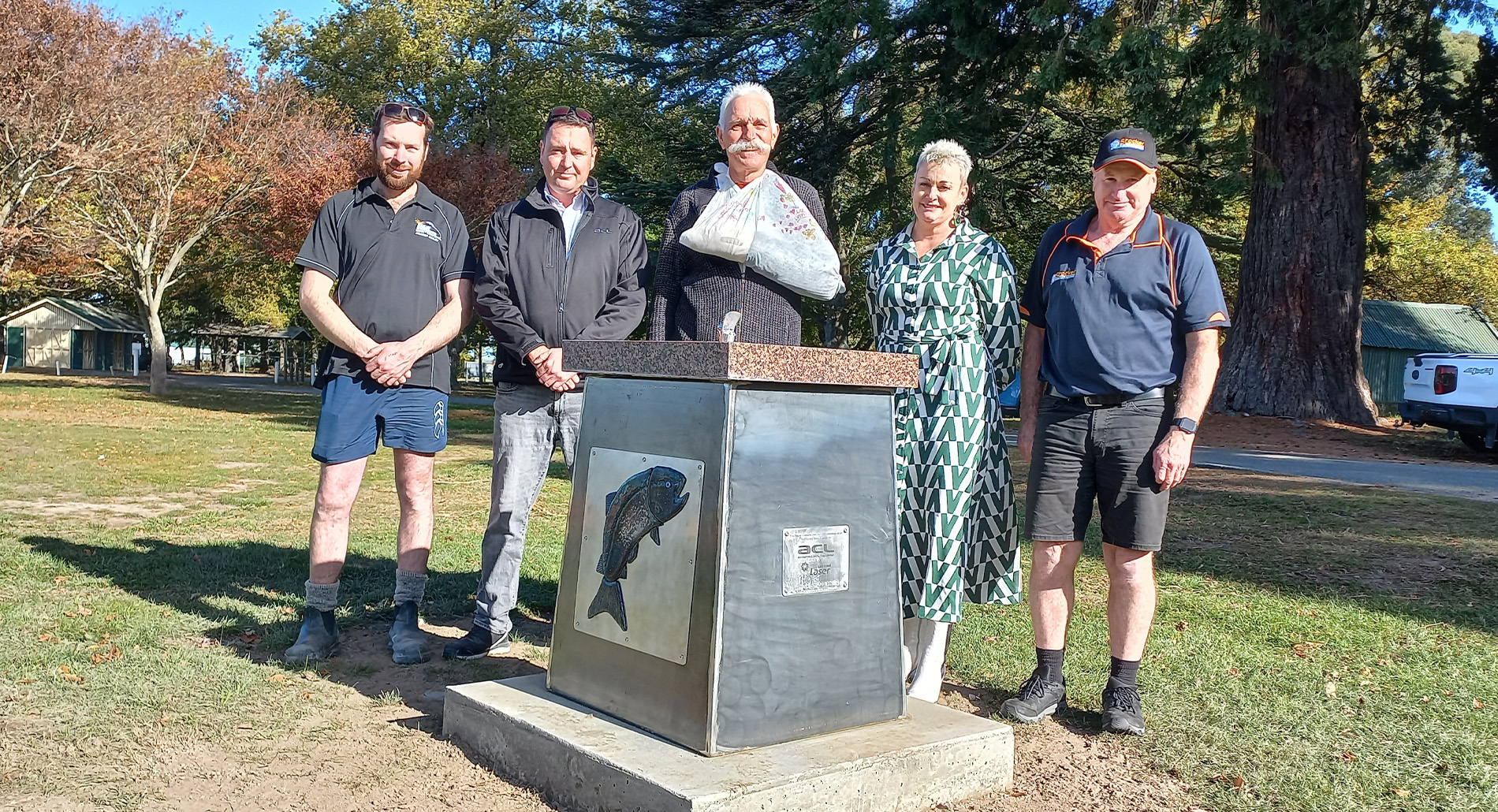 Five adults standing by drinking fountain